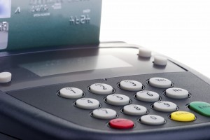 Closeup of credit card swipe on pin pad card reader over white background