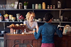 Customer In Coffee Shop Ordering Using Digital Tablet at the POS System