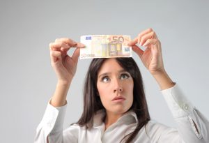 Woman holding up currency currency
