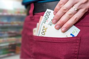 Businesswoman putting euro money banknotes in pocket