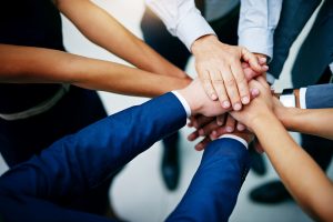 Closeup shot of a group of business people joining their hands together in unity