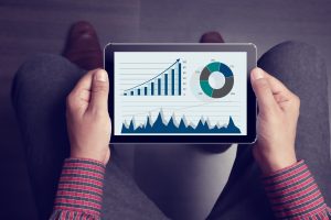 Low section view of a businessman analyzing business graph on digital tablet.