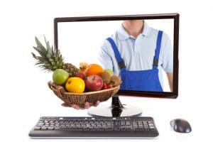 Farmer is holding fruit basket in computer.
