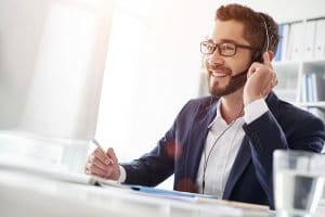 Smiling businessman using headset when talking to customer