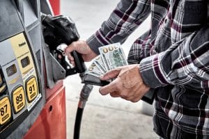 Mans Hand holding Cash while preparing to Refuel Vehicle