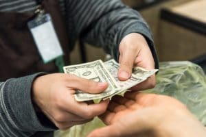 Woman giving cash when paying at a supermarket