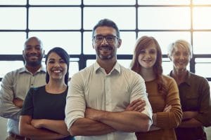 Portrait of a team of colleagues standing together in a modern office