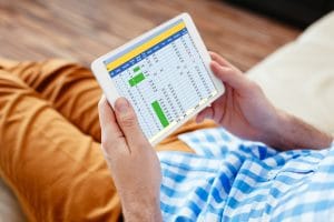 Closeup of digital tablet held by man relaxing at home