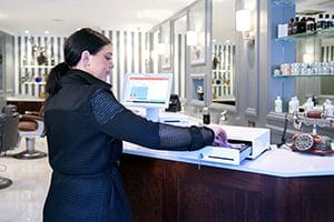 Woman pulling cash out of a cash drawer